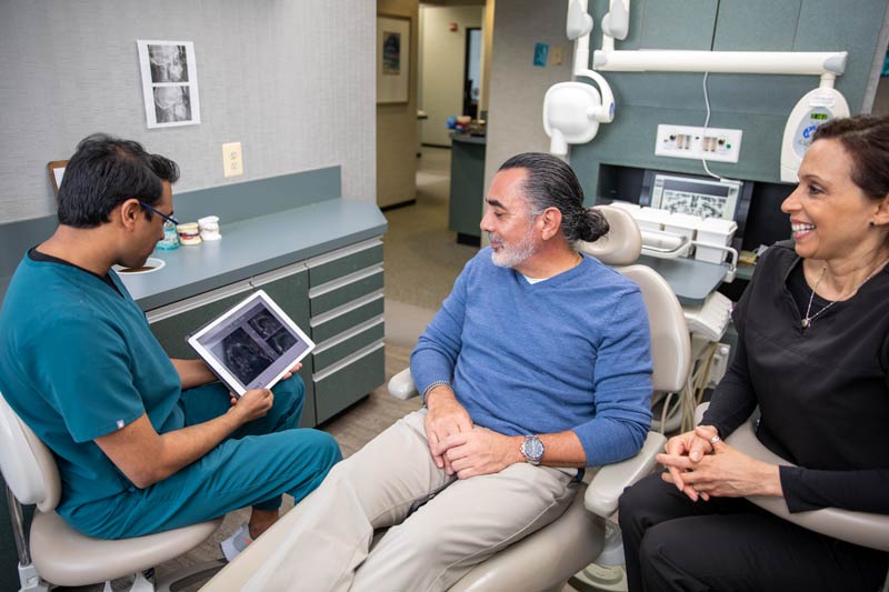 Dr. Gurjar showing dental implant patient Leopold his x-rays